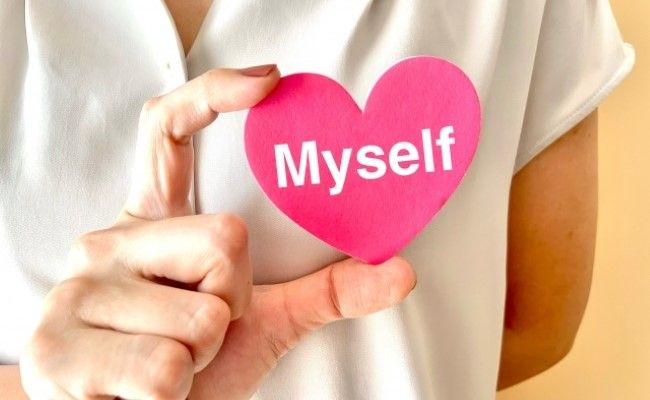 Myselfと書かれたハートマークを持つ女性