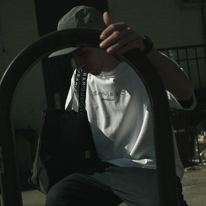 「くだらないことを真面目にやる」ことで定評のあるKen KagamiとCHARI＆COの関係は、なんだかんだで“浅く長く”。そして今回も、例によって例のごとく、“どうでもいい会話”の中から生まれたTシャツとトートのカプセルコレクションが完成した。