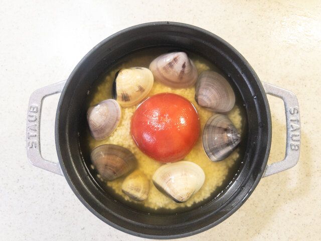 STAUB（鍋または炊飯器の内釜）に、②の米を入れ、真ん中に③のトマトを入れて周りに①のはまぐりを入れる。