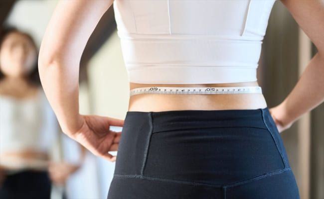 ウエストをはかる女性