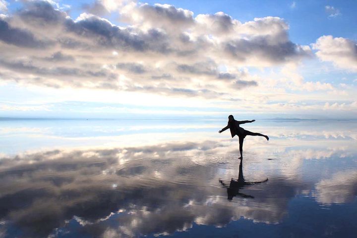 南米ボリビアの広大な塩湖、ウユニ湖にて。雨水が薄く張った貴重な状態に恵まれた