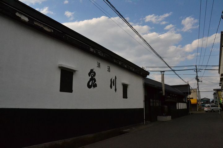 酒蔵の白壁には、代々の銘柄「泉川」が記されている（2015年4月撮影）。