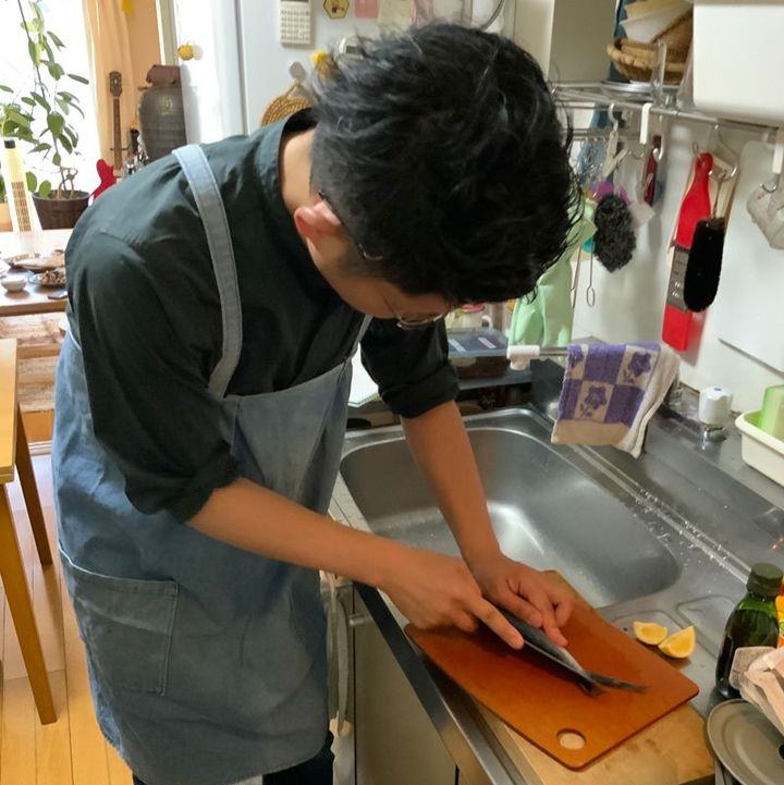 知人夫妻宅の台所でトビウオを3枚に下ろしている筆者（知人撮影）