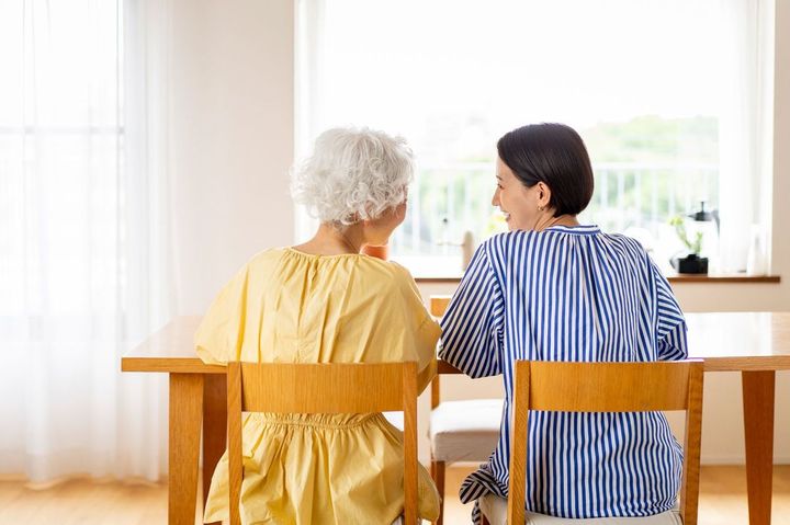 女性が椅子に座って話している