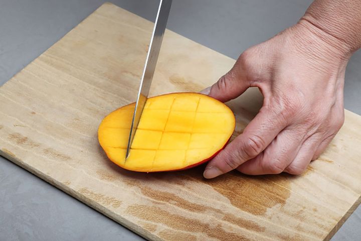 両側のマンゴーの皮を下にして格子状に切り込みを入れましょう。