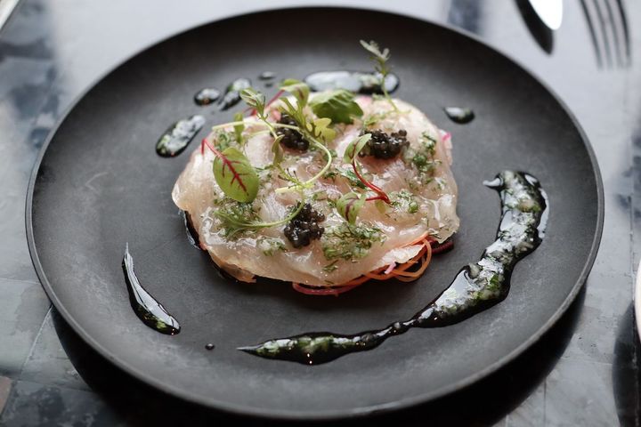 本日の魚料理は、かんぱちの薄造りにキャビアを添えて。酸味の効いたキャロットラペがいいアクセントに。