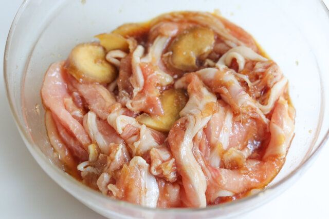 ボウルにしょうゆ、みりん、酒、すりおろしたたまねぎ、しょうがを加えて混ぜ合わせ、豚肩ロース肉を加えてもみ込む。