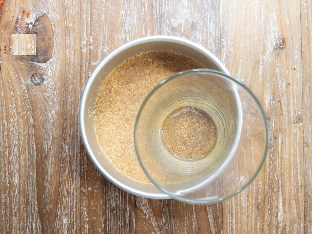 溶かしバターをビスケットになじませ、ケーキ型に敷き詰める。