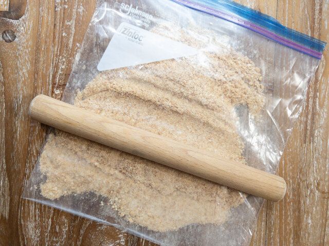 ジップロックにビスケットを入れ、めん棒で粉状に細かく砕きます。