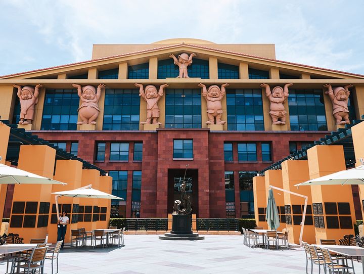 『白雪姫』（1937年）の収益で建てられた本スタジオを象徴する、7人のこびとが支える本社ビル「チーム・ディズニー・ビルディング」。