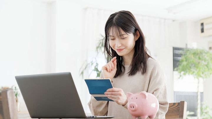 通帳を見て笑顔の女性