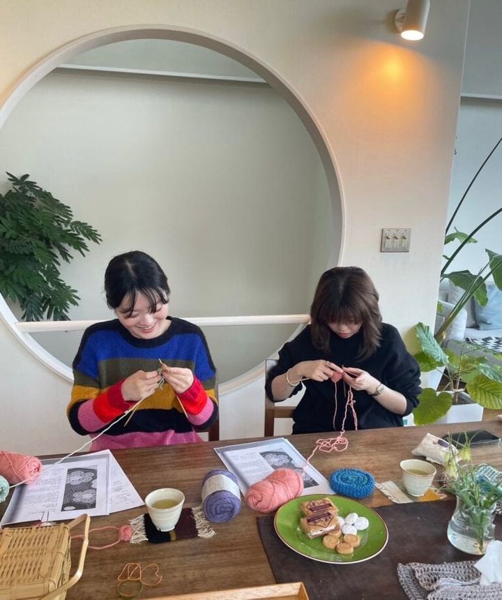 編み物に挑戦する若者2人