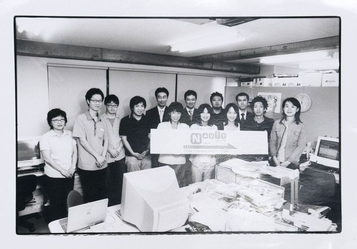 社名を「ナビット」にあらためたころの社内。前列左端で看板を持っているのが福井泰代さん