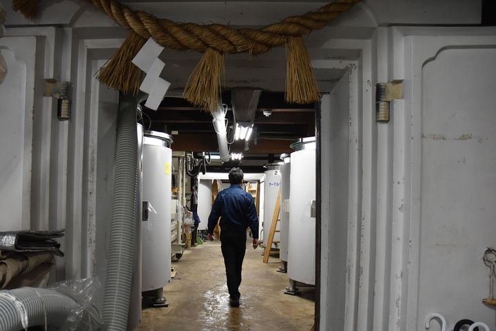 温度管理のできるサーマルタンクの間を歩く廣木さん