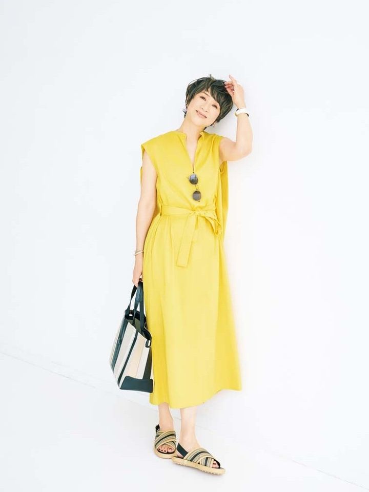 黄色ワンピース¥209,000／ファビアナフィリッピ（アオイ）、サングラス¥96,800／リンドバーグ（ケリング アイウエア ジャパン カスタマーサービス）、ピアス左耳¥23,100、右耳¥25,300／ともにヒロタカ（ヒロタカ ビームス 六本木ヒルズ）、左手バングル¥304,700／ソフィー ブハイ、リング¥82,500／ノアーク、右手チェーンブレスレット¥90,200／ソフィー ブハイ、右手バングル¥46,200／ノアーク（すべてエスケーパーズ アナザーワールド）、バッグ¥237,600、靴¥135,300／ともにトッズ（トッズ·ジャパン）