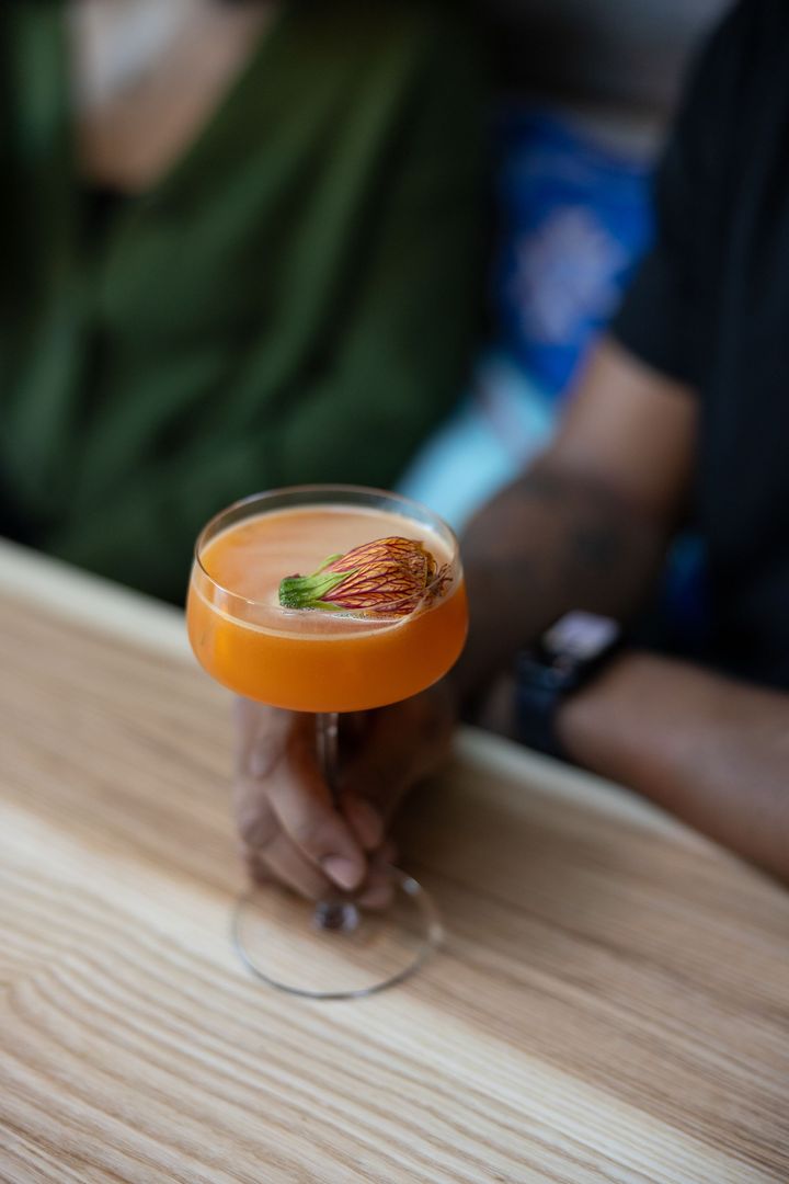 パッションフルーツとオレンジリキュール、ジン、屋上で栽培されたエディブルフラワーのフルーティなカクテル16ドル。