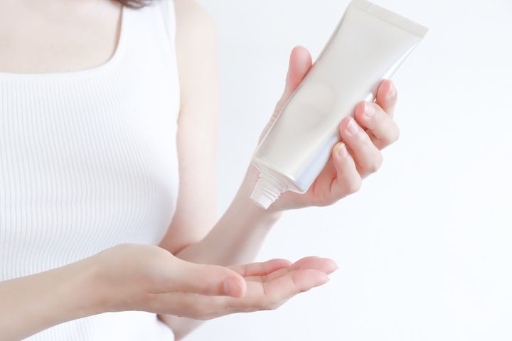 スキンケア 日焼け止めクリームを手に出す女性
