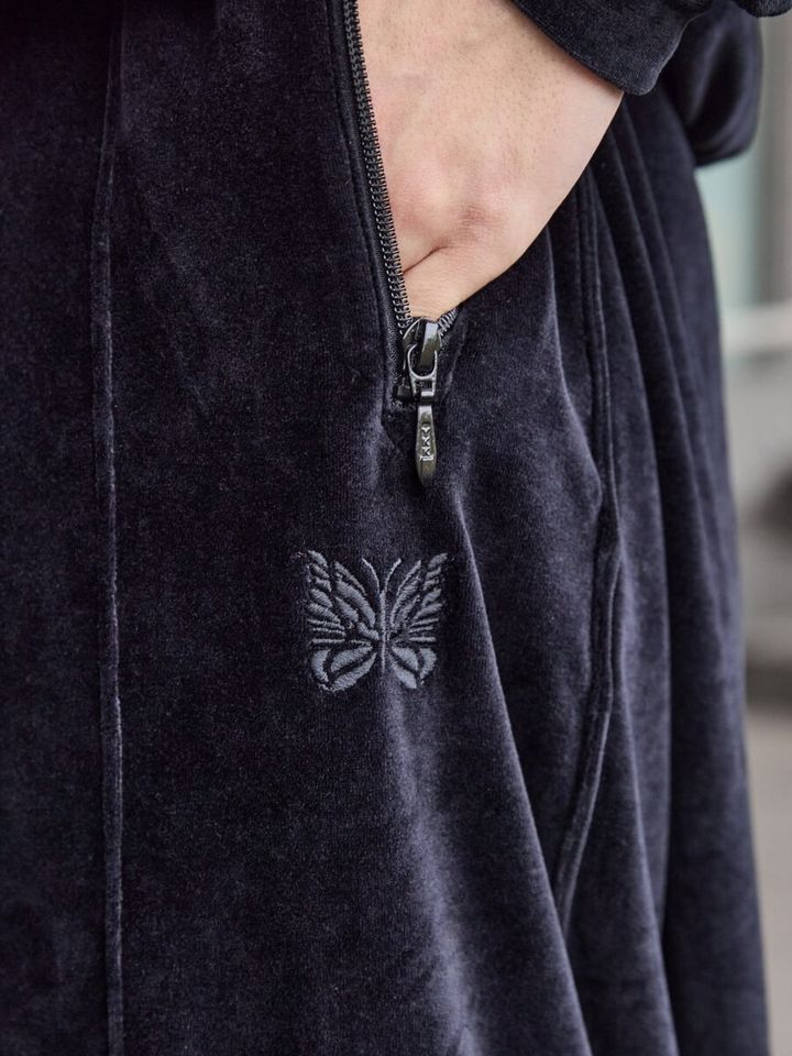 ベロア特有の起⽑感と程よい艶感により上品な雰囲気を纏いつつ、アイコニックなストライプ柄のサイドテープをあえて無くすことでシックな佇まいを演出する。