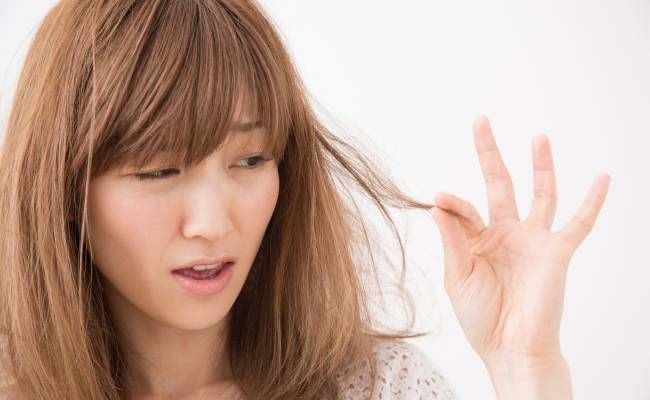 髪の毛質変化に悩む女性のイメージ