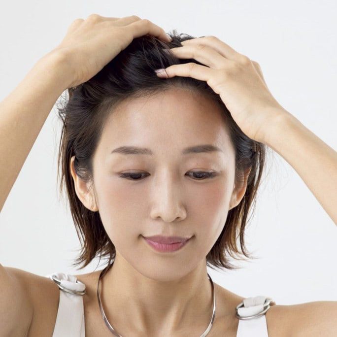 【HOW TO】1．毛先にヘアオイルをなじませたあと、生え際から指を入れてオールバックにします。分け目がぱっくりと割れやすい人は、指先を小刻みに振りながら行えば分け目がぼけてふんわり感が高まります。