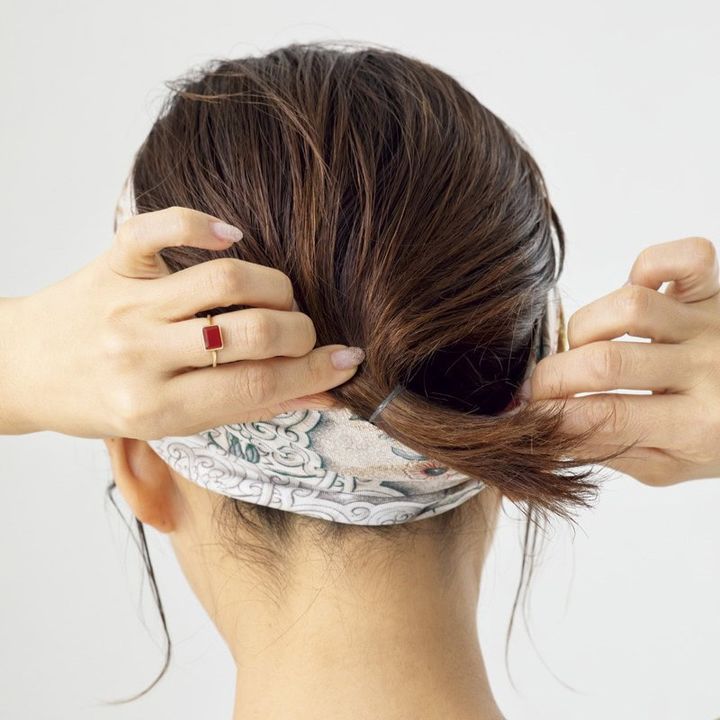 【HOW TO】2．1で残したバックの毛束はゴムで縛ったら、スカーフの内側に入れて隠します。サイドはおくれ毛を一束引き出し、前髪とともに専用スティックでウエット風に固めれば完成！