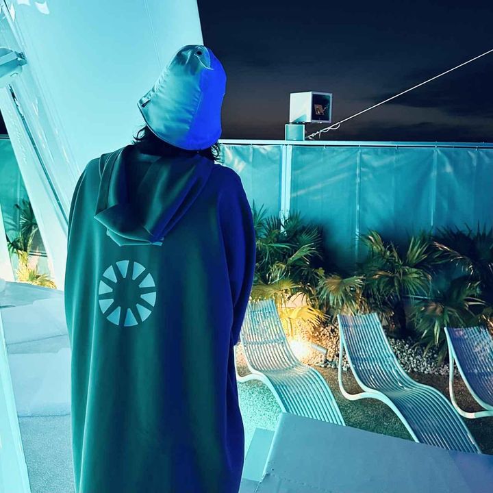 画像: 昼と夜でまったく異なる光の演出が楽しめる「太陽のつぼみ」。サウナテントをモチーフにしたロゴをバックプリントにあしらったサウナガイドのユニフォームは「SOPH.（ソフ）」とのコラボで、来場者も購入可能