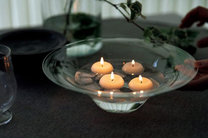 七夕など夏の夕暮れどきに楽しむフローティング キャンドル。香川県に工房を構えるガラス作家・ 蠣﨑マコトさんのボウルに水と氷を張って。