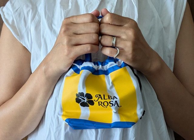 ALBA ROSA 巾着ポーチを手に持った様子