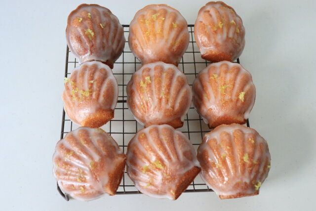 マドレーヌの表面に刷毛で塗り、削ったレモンの表皮を飾る。