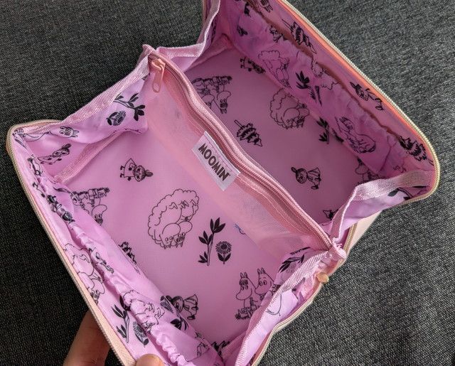 内部全景：内側はムーミン総柄。中央はファスナー付きメッシュ仕切り、周囲にゴム付きポケット