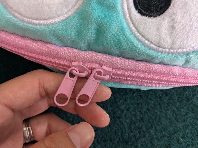 前面のピンク色ダブルファスナーの引き手アップ