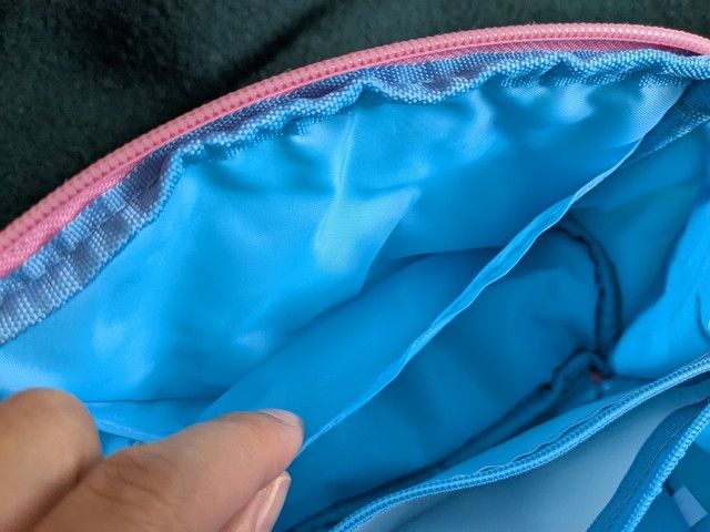 薄い仕切りポケットを指で示したクローズアップ