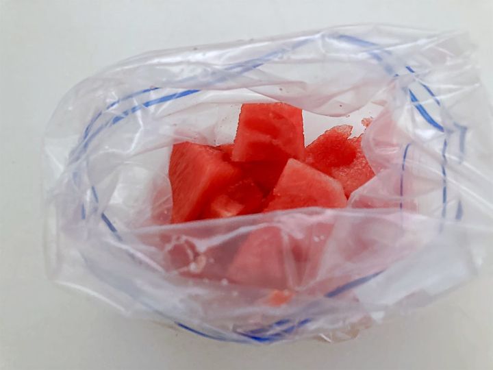 種を取ったすいかを袋に入れる