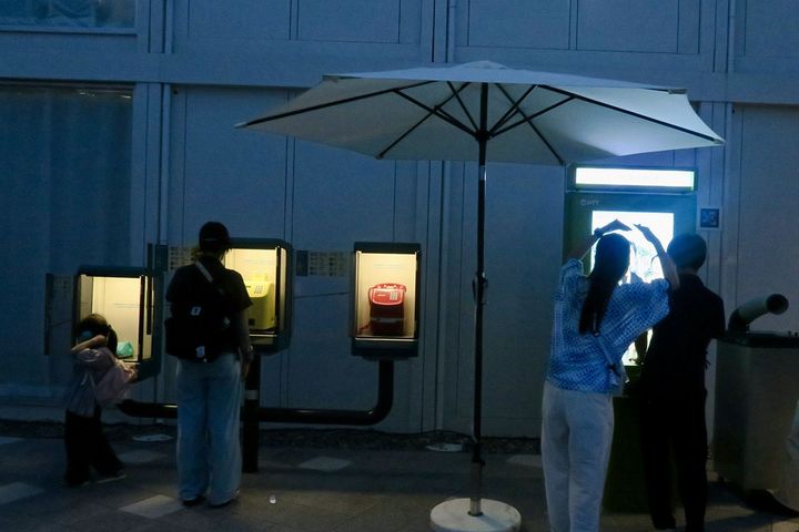 「NTT Pavilion」敷地の一画に設置された、昭和レトロな公衆電話機（左3台）と未来の伝話機（右端）。予約なしで誰でも気軽に体験することができます。