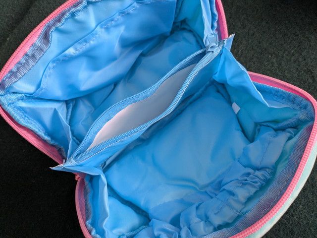 ポーチを大きく開いた内装全体。中央のファスナー付き仕切りと両サイドのゴムポケットが見える