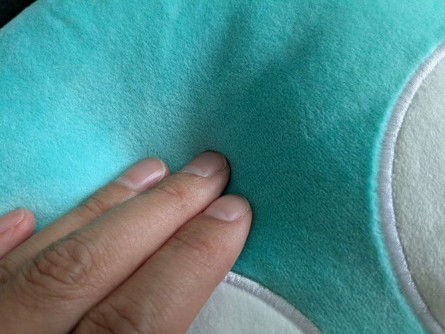 やわらかく弾力のあるクッションの触感を手で確かめている様子