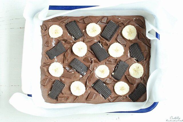 バッドにチョコヨーグルトを流し入れ、上にバナナと割ったクッキー、チョコレートをバランスよくのせ冷蔵庫で一晩冷やし固める。