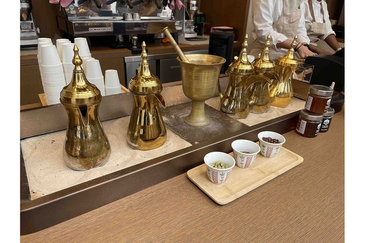 サウジコーヒーの伝統的な道具。コーヒーやスパイスをすり潰す「ハワン」（中央）、コーヒーの煮出しや保温に使うポット「ダッラ」（左右）。熱した砂の上にダッラを置いて保温中。