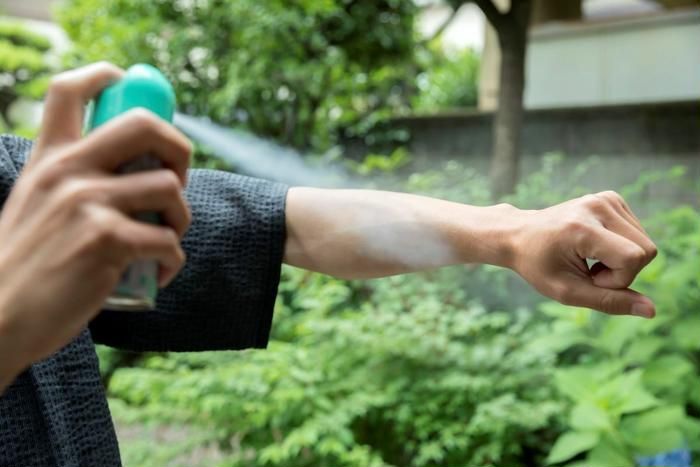 腕にスプレーをかけている様子
