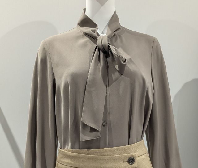 ブラウンのボウタイブラウスを着たマネキン