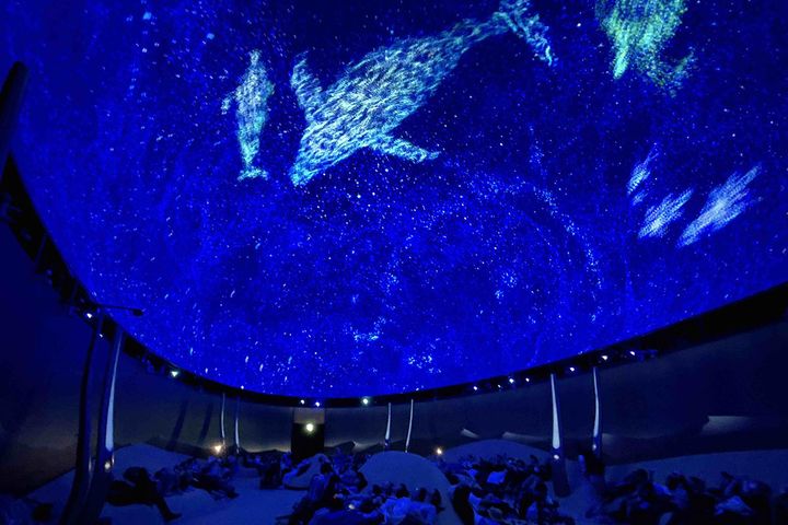 クウェート・パビリオン展示の一つ「先見の明かり」。砂丘をイメージしたスペースに座って満点の星空などの映像を眺めることができます。