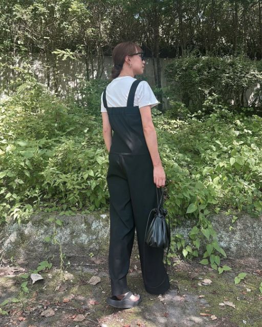 黒のタックサロペットパンツQを着たコーデの後ろ姿