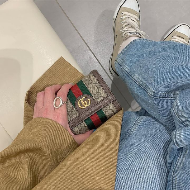 グッチのミニ財布をもった女性