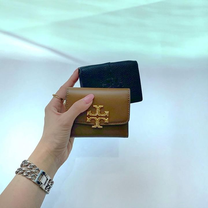 2つのミニ財布を持つ女性