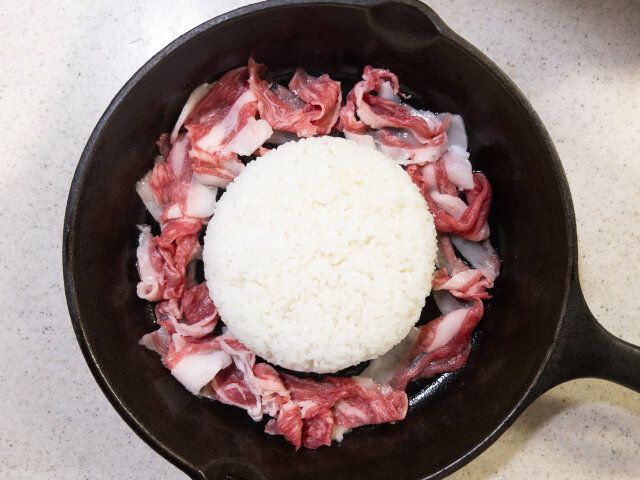 スキレット（フライパン）の真ん中にご飯を盛り付け、周りに牛肉を並べます。