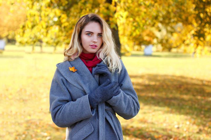 コートにブローチをつけた女性