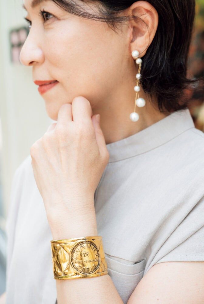 装いの引き締め役は「シャネル」のバングル。「母のパリ土産です。大ぶりなコットンパールのピアスは『カリーヌ』です」
