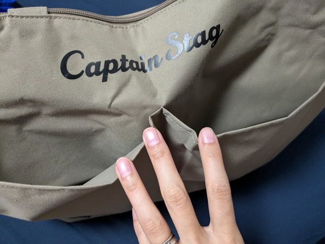 BIGトート外ポケットの仕切り部分を指で示すディテール