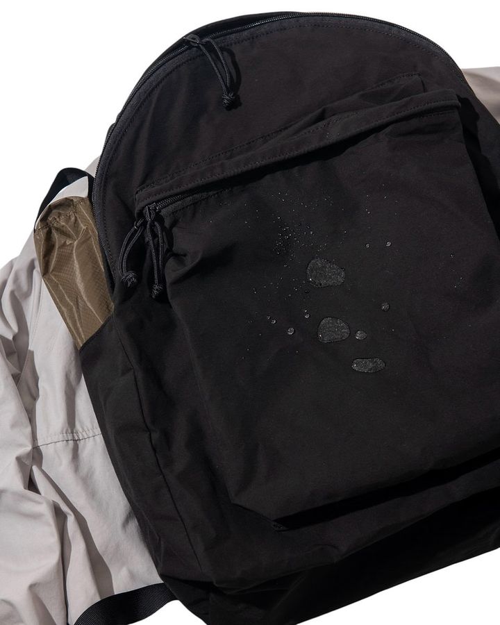 素材はMT.RAINIER DESIGNを代表する素材「60/40（ロクヨン）クロス」を採用。 横糸にコットン 60%、縦糸にナイロン 40%を組み合わせた独自の織りは、雨に濡れ るとコットンが膨張し、ナイロンの撥水性と相まって水を弾く特性を発揮する。 完全防水ではないものの、日常の雨には十分対応。さらに経年変化による豊かな風合 いや、大容量でありながら軽量性を兼ね備えている点も特長だ。