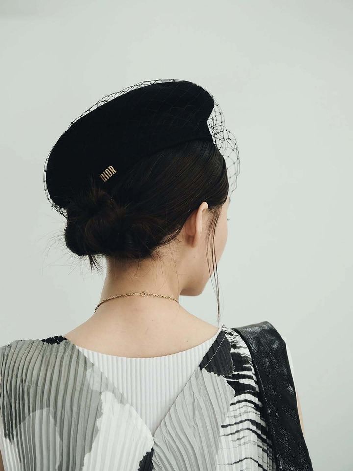 おしゃれな黒い帽子を身に着ける女性のうしろ姿